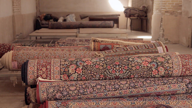 Kerman Rugs Rolled up in a pile